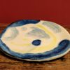 Glazed earthenware plate with bue and yellow designsdesigns.