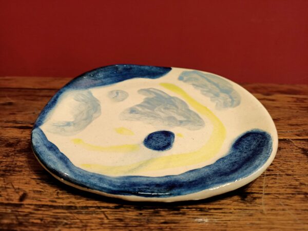 Glazed earthenware plate with bue and yellow designsdesigns.