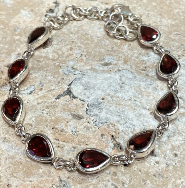 Sterling silver and garnet bracelet with drop shape stones.